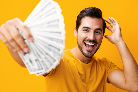 Man currency dollar rich happy finance money smiling cash background yellow businessの写真素材
