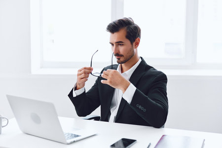 Man in office businessman sitting at desk and working in laptop, finance and startup concept, working lifestyle in bright office.の写真素材