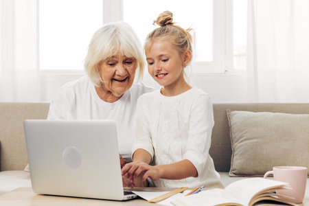 Granddaughter smiling family grandmother togetherness laptop child bonding selfie huggingの写真素材