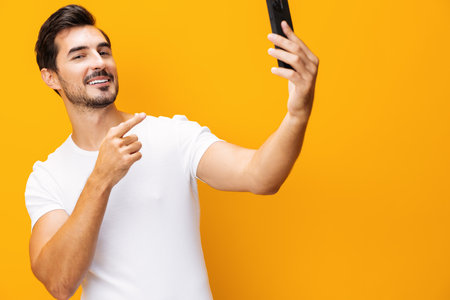 Man space technology phone studio communication phone mobile yellow smiling portrait smartphone happy copy cyberspaceの写真素材