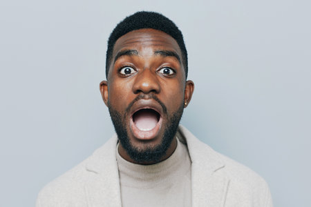 Happy young African American gen z guy isolated on beige background. Smiling hipster ethnic teen student, cool curly ethnic generation z teenager fashion model standing looking at camera, portrait.の写真素材