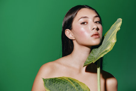 Beauty of a Young Female Model: A Pretty Portrait of an Attractive Lady with Fashionable Hair and Clean, Healthy Skin, Posing Sensually on a Green Nature Background.の写真素材
