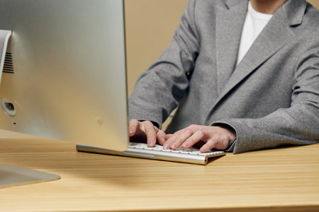 Woman working on laptop in office; professional, focused, business environment, modern technology.