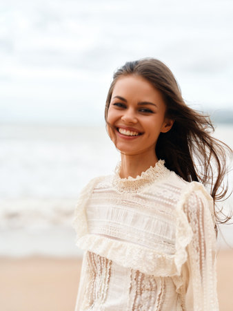 Cheerful Young Woman with Attractive Smile, Enjoying Sunny Summer Vacation on a Beach, Relaxing in the Calm of Natureの写真素材