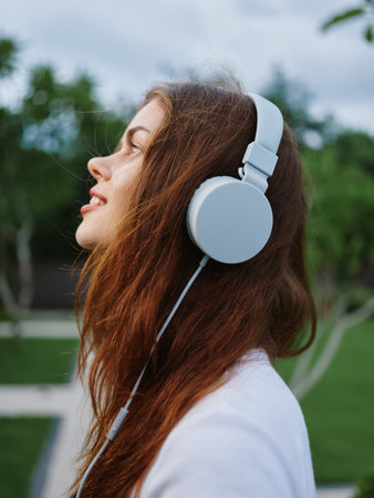 Portrait of a woman wearing headphones close-up smile with teeth flying hairの写真素材