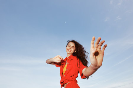 Smiling Woman Dancing with Joy by the Azure Sea on a Sunny Beach, Enjoying Freedom and Summer Fun