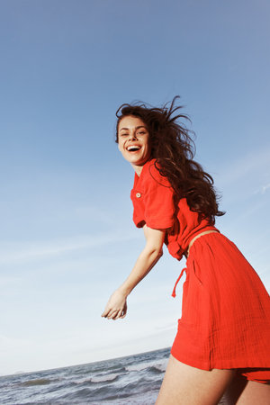 Smiling Woman Dancing in the Joy of Summer Fun at the Beachの写真素材