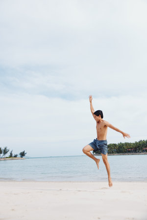 Muscular Asian Athlete Running on the Beach, Embracing Fitness and Wellnessの写真素材