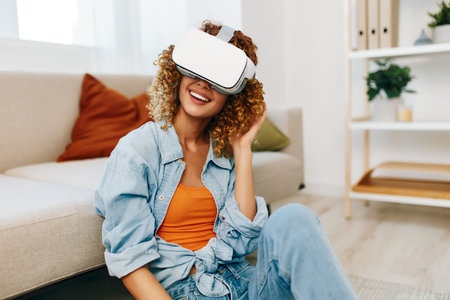Smiling Woman Enjoying Virtual Reality Game at Home with Futuristic VR Glassesの写真素材