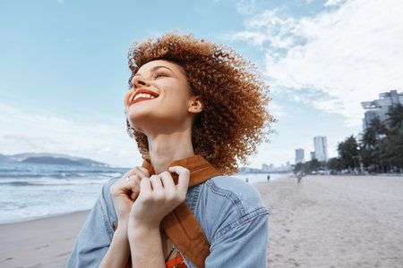 Smiling Woman Enjoying the Freedom of a Beach Vacation: A Happy Hippie Traveler with Open Mouth and Curly Hair, Portrait in Natureの写真素材