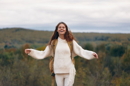 Mountain Adventure: Smiling Woman with Backpack on Cliff, Enjoying Nature and Freedomの写真素材