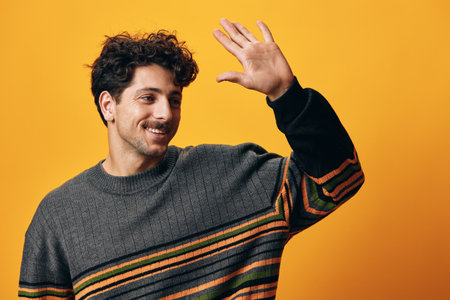 Man hispanic portrait fashion orange guy serious trendy smile student sweater background happyの写真素材
