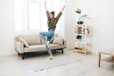 Jumping for Joy: A Carefree Woman Dancing and Singing in a Beautiful Home Interior.の写真素材