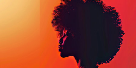 Silhouette of woman with afro hair in front of vibrant orange and red background, showcasing beauty and diversityの素材