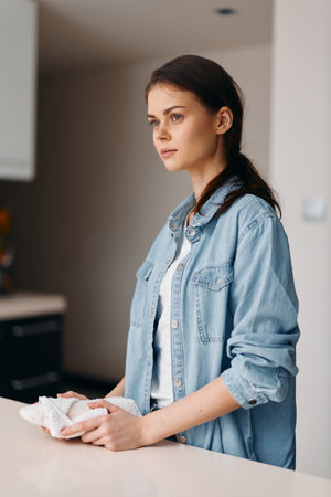 Pretty Young Caucasian Woman Standing in a Modern Kitchen, Cooking a Healthy Breakfast in a White...