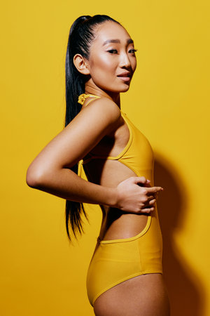 Trendy woman summer beauty surprised skin swimsuit yellow smile portrait lady fashionの写真素材