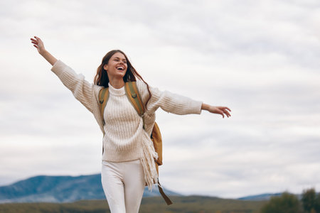 Mountain Adventure: Smiling Woman on Cliff, Enjoying Outdoor Travel and Hiking in Springtimeの写真素材
