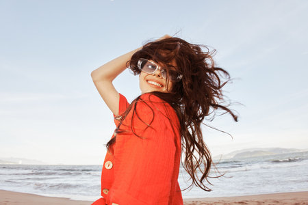 Smiling Woman in Colorful Sunglasses, Embracing Freedom, at the Wide Angle Beach Portraitの写真素材