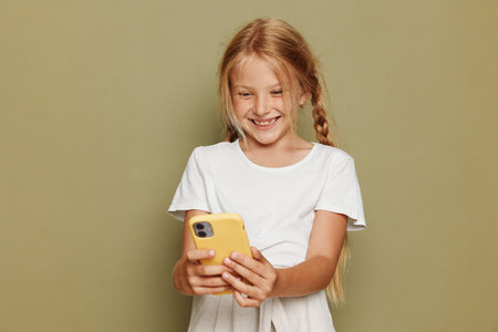 Smiling Young Girl Holding Smartphone on Beige Background