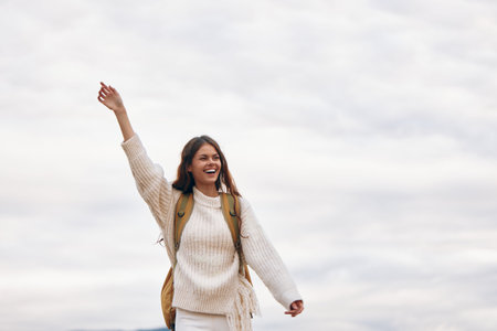 Mountains Smile: Stylish Woman Enjoying Adventure and Freedom on Cliffの写真素材