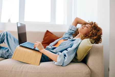 Cyber Happiness: Smiling Woman in Home Office, Typing on Laptop, Enjoying Freelance Successの写真素材