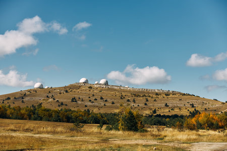 Three powerful telescopes capturing the beauty of the cosmos from a remote hilltop observatory on a clear dayの写真素材