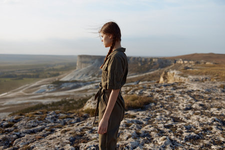 Woman standing on top of hill with view of valley below, enjoying nature and travel beautyの写真素材