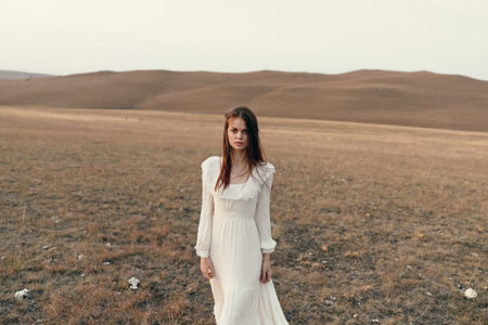 Woman standing in majestic mountain field tranquil nature beauty and fashion photography conceptの写真素材