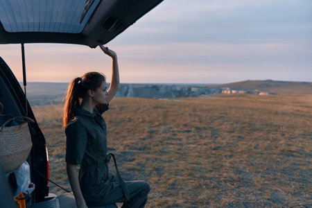 Woman enjoying a relaxing ride in the backseat of a car on a business trip with arms raised in airの写真素材