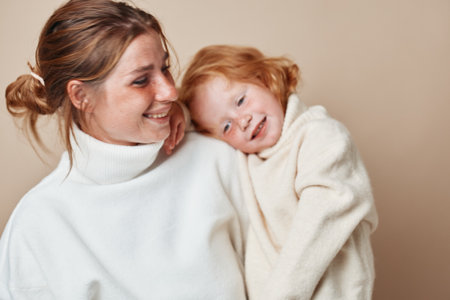 Mother and daughter embracing in white turtlenecks, love and beauty captured in a tender momentの写真素材