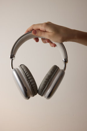 Person holding headphones on white background with copy space