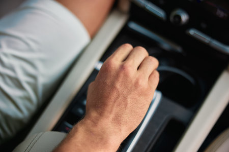 Close up of a hand adjusting the gear shift in a modern car interiorの写真素材