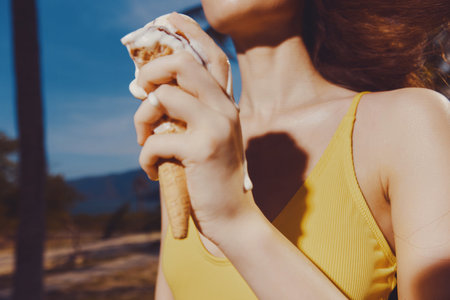 Woman enjoying ice cream cone on a sunny day with a blurred backgroundの写真素材