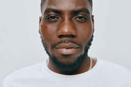 Portrait of a confident man with a beard wearing a white t shirt, exuding positivity and self assurance against a light gray background Captures strong emotions and characterの写真素材
