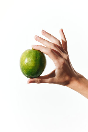 Hand holding lime on white background