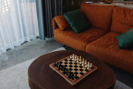 Chess board on coffee table in front of couch in cozy living room interior