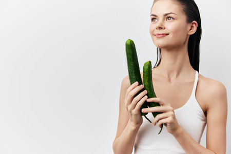 cucumber, healthy lifestyle, wellness, woman holding cucumbers, skincare, freshness, natural beauty, clean eating, vegetable benefits, organic lifestyle, clean backgroundの写真素材