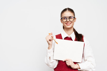 smiling woman holding blank whiteboard, wearing glasses, in a bright studio background, showing creativity and readiness for a presentation or brainstorming session, engaging concept, cheerful atmospの写真素材