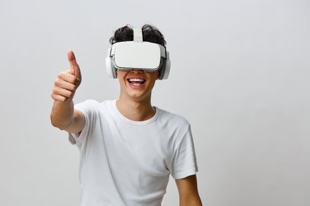 VR technology, virtual reality, young man, joy, thumbs up, modern lifestyle, headset, smilingの写真素材