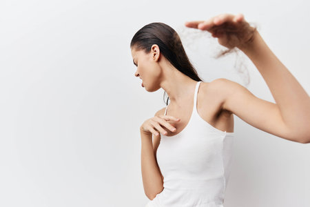 Female model posing gracefully against a plain white background, showcasing elegance and poise. The focus is on her serene expression and dynamic movement.の写真素材