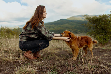 Woman and dog enjoying the tranquility of nature in front of breathtaking mountain views on a peaceful hilltop retreatの写真素材