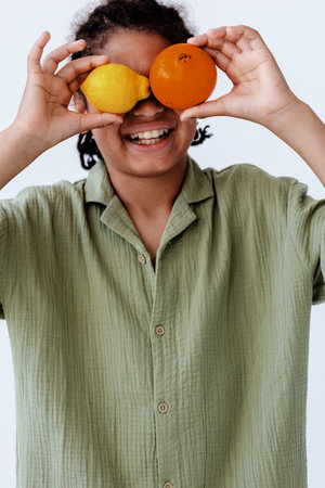 Fruitful vision woman in green shirt holding oranges and lemon in front of eyesの写真素材