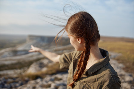 Adventure begins woman with braided hair standing on hilltop with outstretched hand in nature beauty landscapeの写真素材
