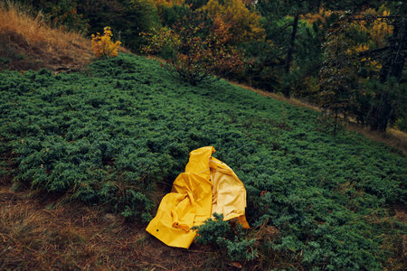 Tranquil getaway person in yellow raincoat enjoying a peaceful moment in the grassy fieldの写真素材