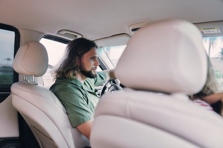 Driver in a car interior with a thoughtful expression, focusing on the road ahead Soft light filters...