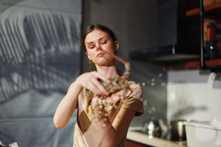 Woman cooking lobster in home kitchen for delicious seafood meal preparationの写真素材