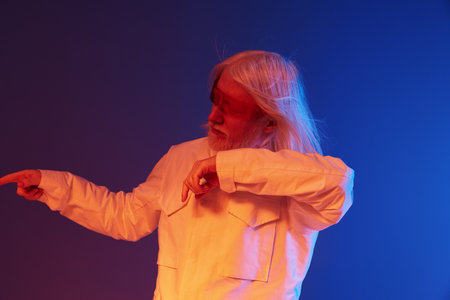 portrait of an elderly man in a white outfit, performing an expressive gesture against a colorful...