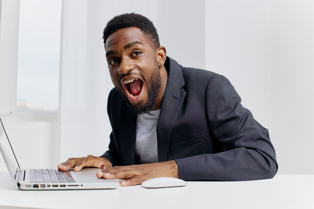Businessman in shocked surprise while viewing unexpected news on laptop at office desk