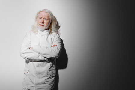 elderly man with long white hair in a white coat against a gradient background, displaying confidence and professionalism, ideal for concepts related to science or healthcareの写真素材