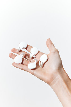 Hand holding set of four white plastic sponges on white backgroundの写真素材